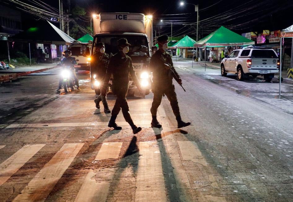 Filipino army troopers patrol a street in the Philippines in the early morning, March 15, 2020. 