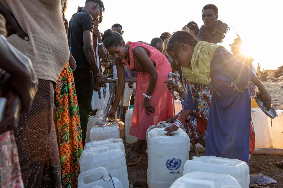 Women pour water into containers at Um Raquba refugee camp in al-Gadaref state, eastern Sudan, November 27, 2020. 
