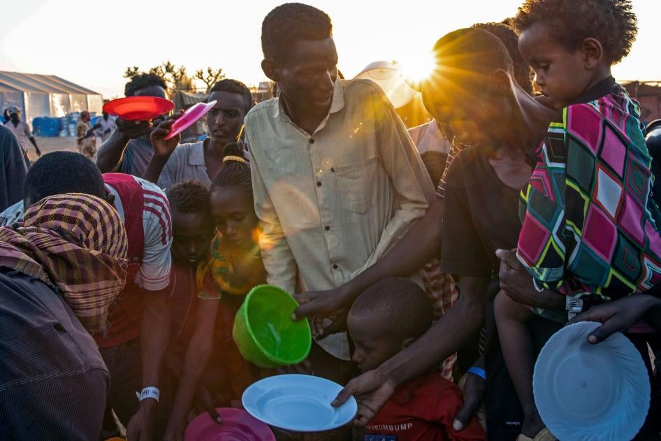 People who fled the conflict in Ethiopia's Tigray region wait for food at Um Raquba refugee camp in al-Gadaref state, eastern Sudan, November 23, 2020. 