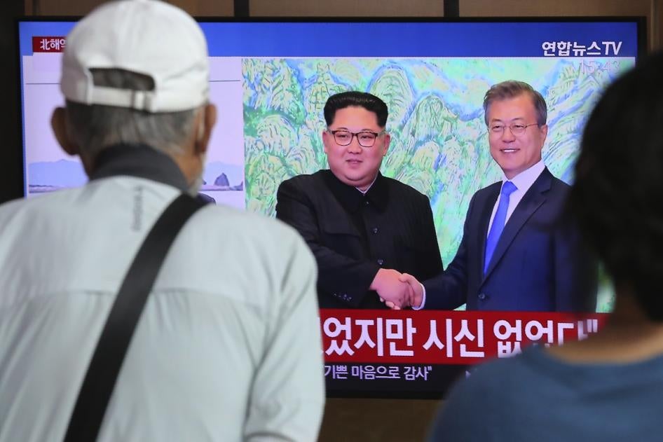 People watch a news program showing an image of North Korean leader Kim Jong Un, left, and South Korean President Moon Jae-in, right, at the Seoul Railway Station in Seoul, South Korea on Friday, Sept. 25, 2020. 