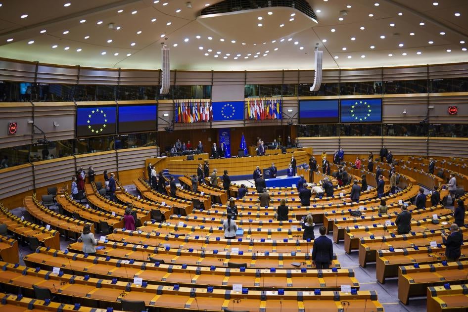 European lawmakers stand up during a signing ceremony at the European Parliament, Brussels, Belgium, March 10, 2021. 
