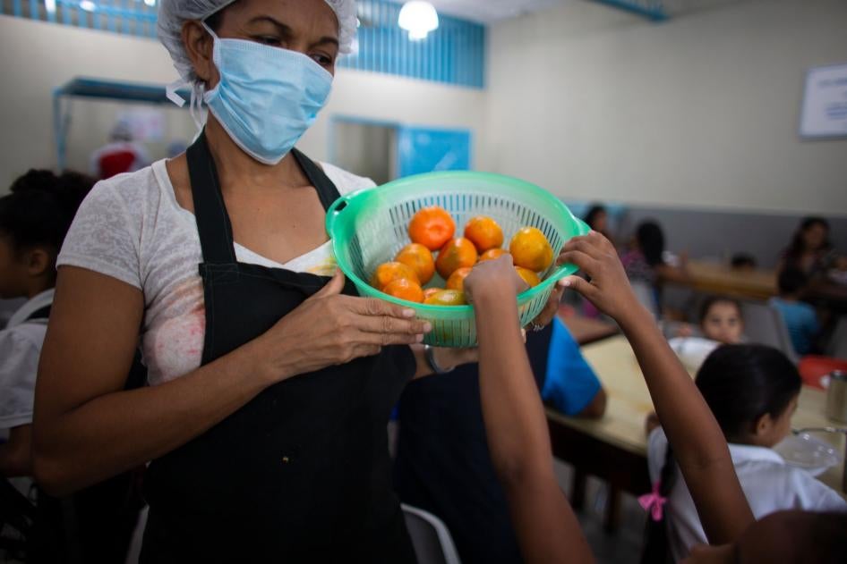 A girl reaches for a tangerine at a soup kitchen in Petare, Venezuela, February 27, 2020. 