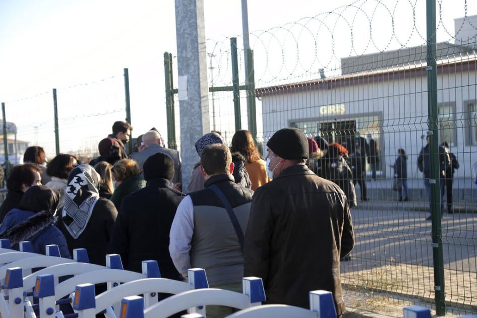 People wait outside a courthouse before the trial of 475 defendants in Ankara, Turkey