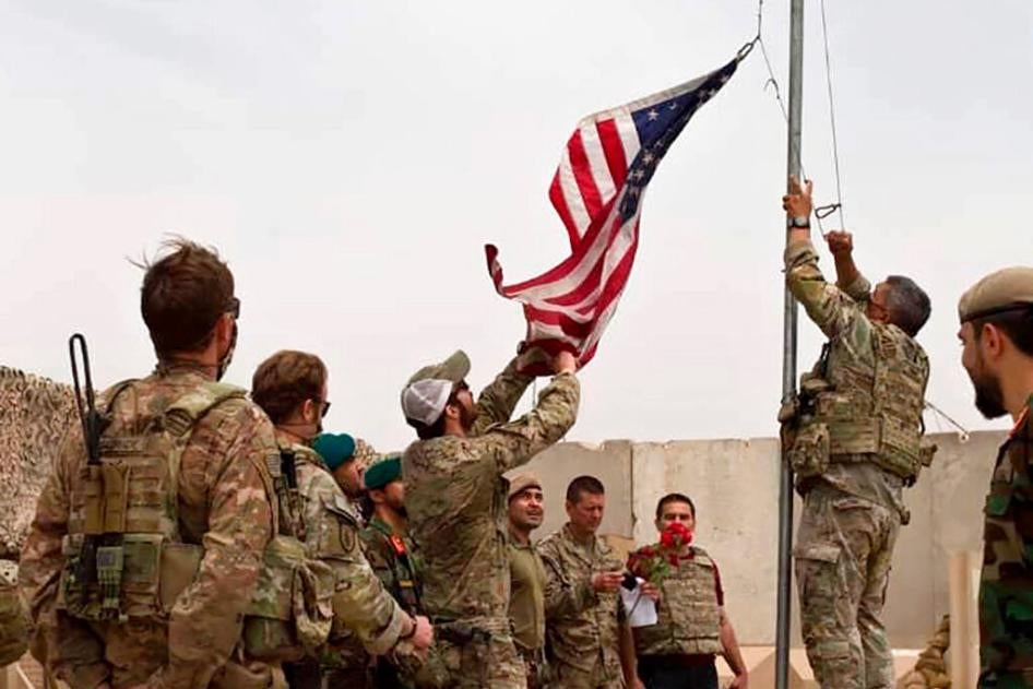 A US flag is lowered as American and Afghan soldiers attend a handover ceremony from the US Army to the Afghan National Army, at Camp Anthonic, in Helmand province, southern Afghanistan on May 2, 2021.