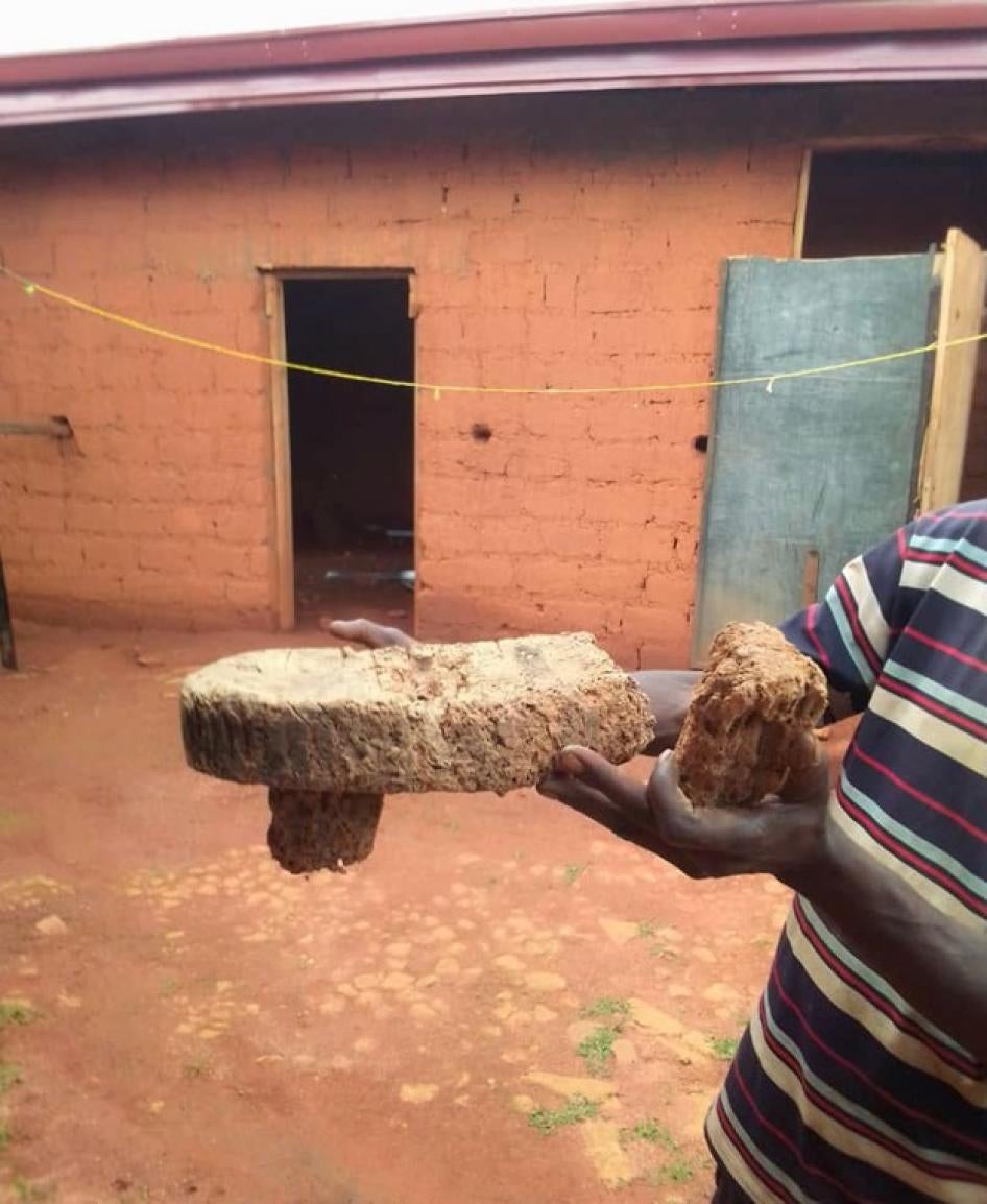 A man holds what is left of the ancestral royal throne of the ‘Fon’, the traditional authority of Ndzeen village. The throne was deliberately destroyed by Cameroonian soldiers during a security operation in Ndzeen on June 9, 2021.  Residence of the ‘Fon’, Ndzeen, North-West region, Cameroon, June 9, 2021 