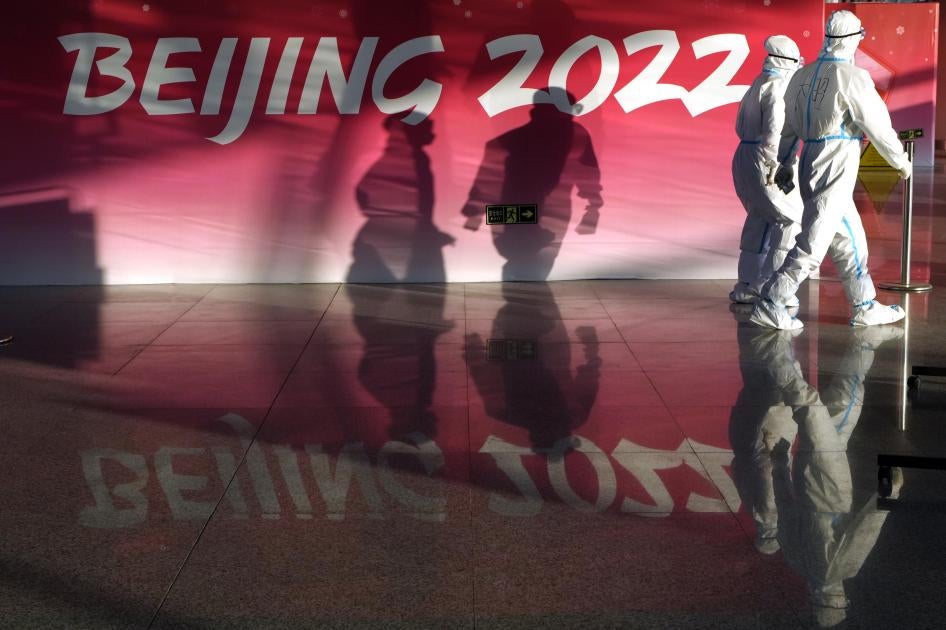 Olympic workers in protective gear walk through the Beijing Capital International Airport to assist passengers ahead of the 2022 Winter Olympics, in Beijing, January 31, 2022. 