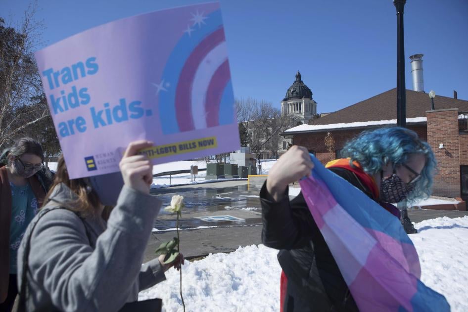 A protester holds a sign that reads "Trans kids are kids"