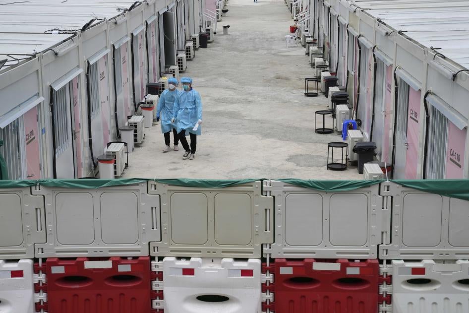 Healthcare workers walk along the makeshift Covid-19 isolation facilities in the San Tin area of Hong Kong, March 11, 2022. 