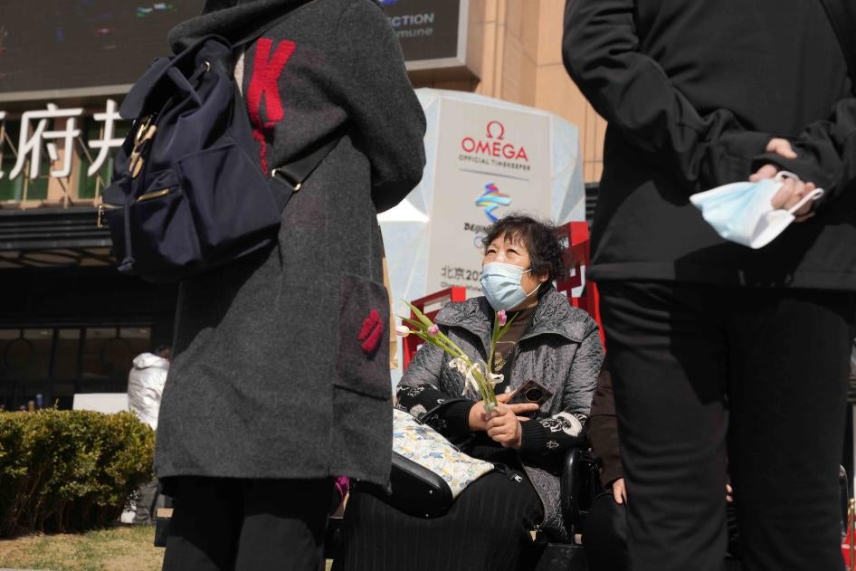A woman holds flowers on International Women's Day on March 8, 2022, in Beijing.