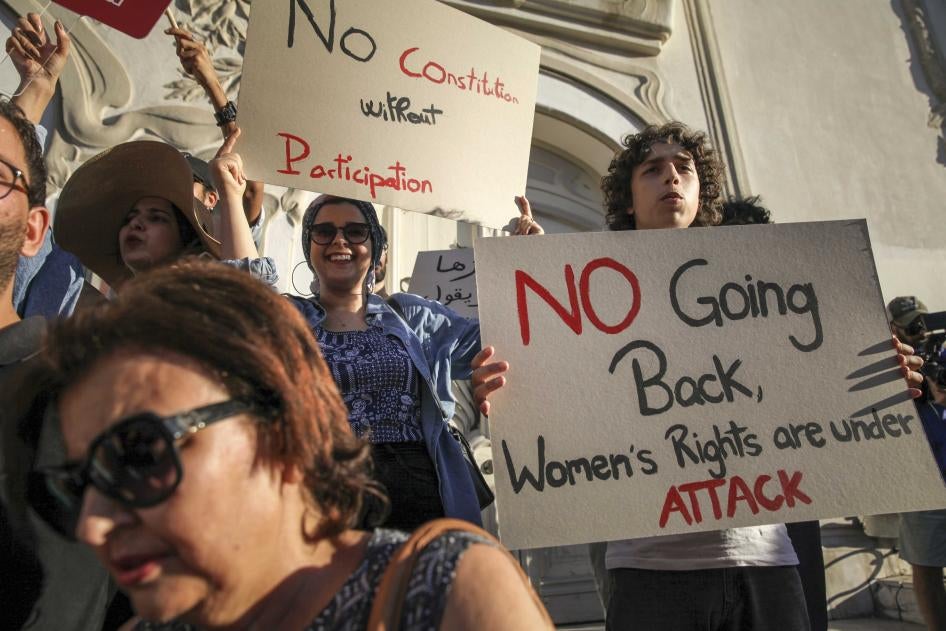 Une Tunisienne manifeste en brandissant une pancarte sur laquelle on peut lire : « Pas de retour en arrière, les droits des femmes sont attaqués », lors d'une protestation contre le président Saied sur l'avenue Habib Bourguiba à Tunis, le 22 juillet 2022. 