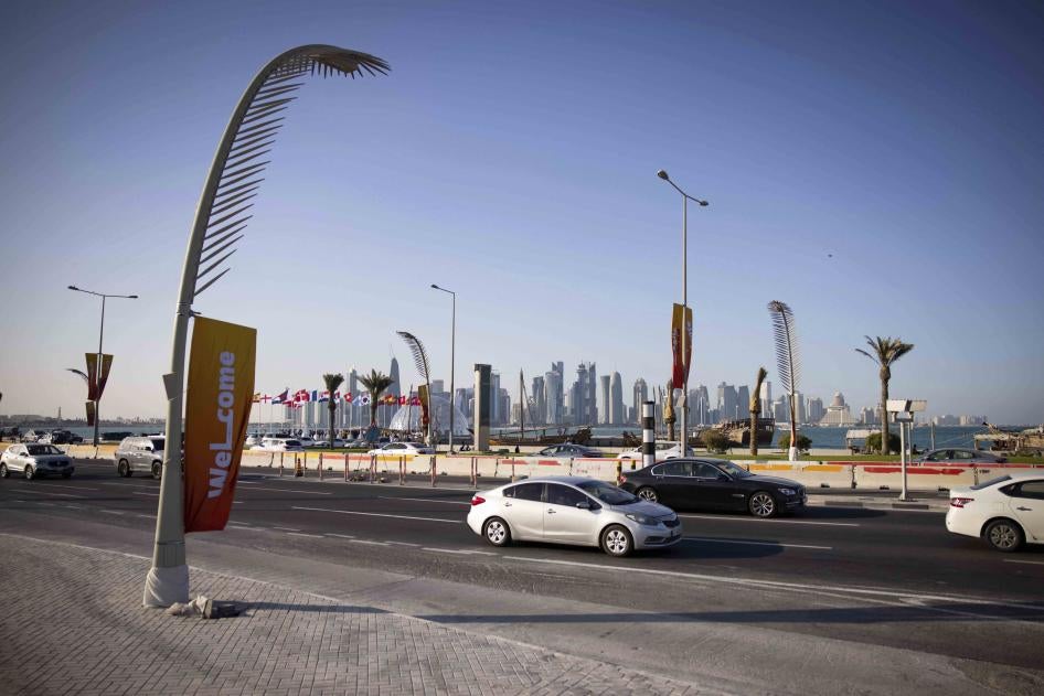 Evening traffic on the Corniche promenade with the skyline of West Bay Doha the background 