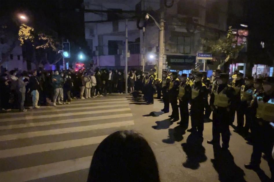 Des policiers chinois déployés devant un groupe de personnes qui s'étaient rassemblées à Shanghai le 27 novembre 2022, entravant ainsi leur tentative de manifester contre la politique draconienne « zéro Covid&nbsp;».