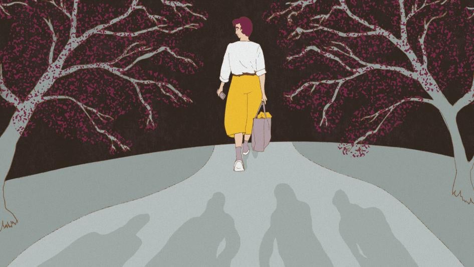 A person holding a cell phone is followed by shadowed men on the street