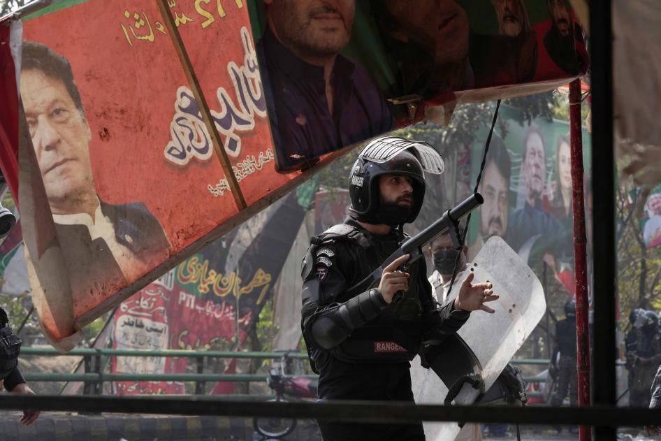 A riot police officer looks on after firing tear gas to disperse supporters of former Prime Minister Imran Khan during clashes in Lahore, Pakistan, March 15, 2023.