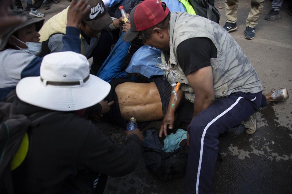 A man lying on the ground with pellet holes in his back
