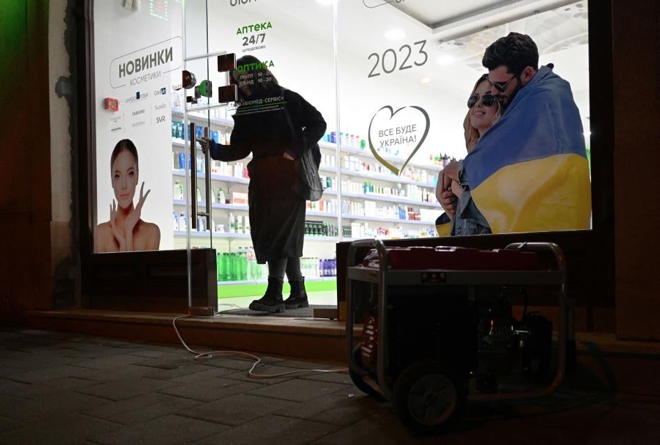 A customer walks out of a drugstore lit by a portable generator during a blackout in the Western Ukrainian city of Lviv following massive Russian airstrikes on January 14, 2023. 