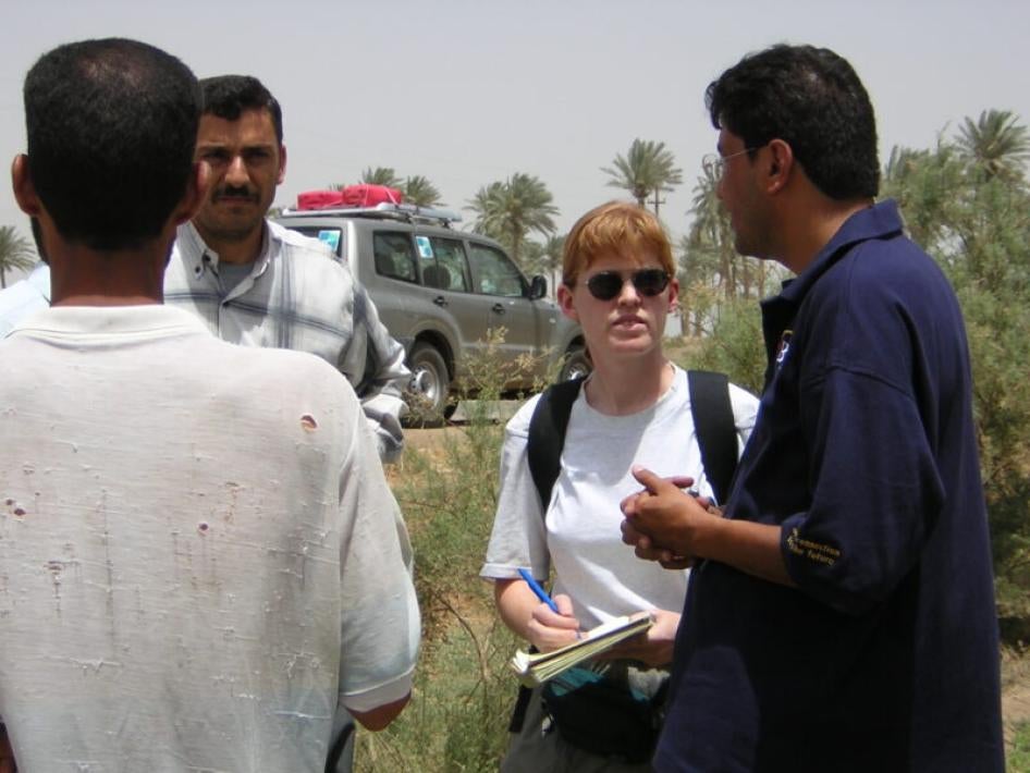 Interpreter Razzaq al-Saiedi (right) and Bonnie Docherty (left) interview Iraqis affected by cluster munitions near al-Hilla in May 2003. 