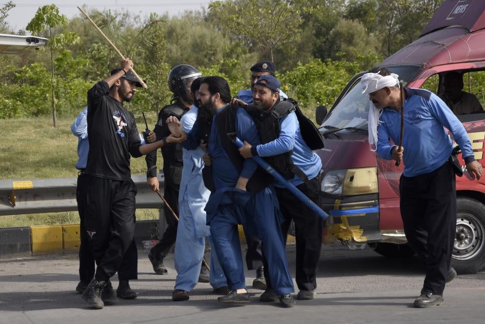 Police detain a supporter of Pakistan's former Prime Minister Imran Khan during clashes, in Islamabad, Pakistan.