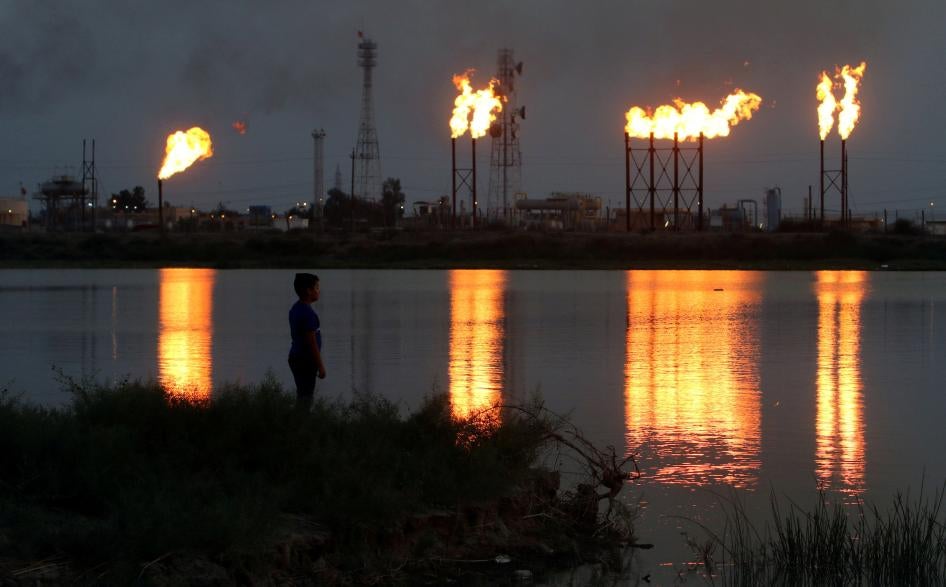 Flames emerge from flare stacks at Nahr Bin Umar oil field, north of Basra, Iraq.