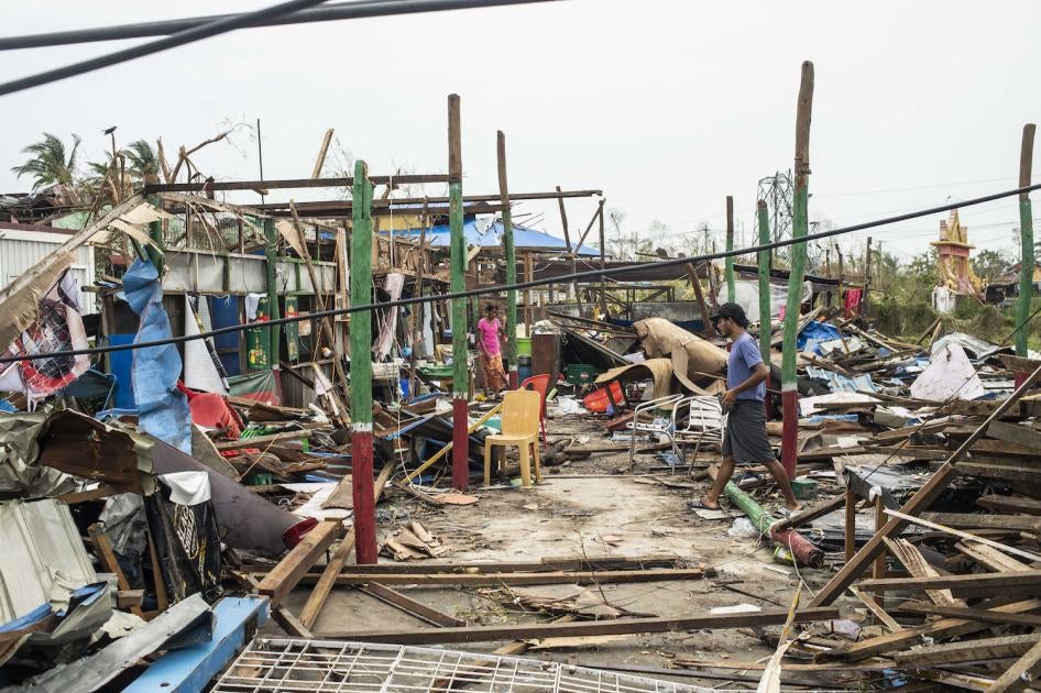  Local residents walk past damaged buildings after Cyclone Mocha in Sittwe township, Rakhine State, Myanmar, May 16, 2023. 
