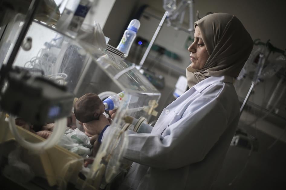 A Palestinian doctor in a hospital in Rafah in the southern Gaza Strip prepares a premature baby to be transferred to Egypt to receive proper medical care, November 20, 2023. 