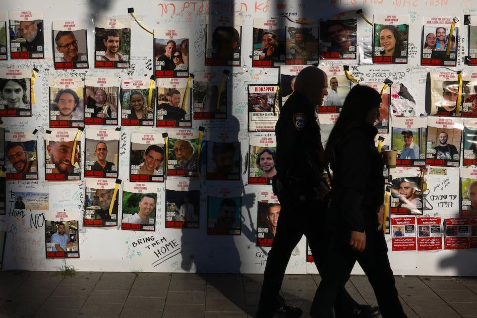 People pass by portraits of Israeli hostages from Israel held in Gaza since the October 7 attacks in Tel Aviv, December 17, 2023. 