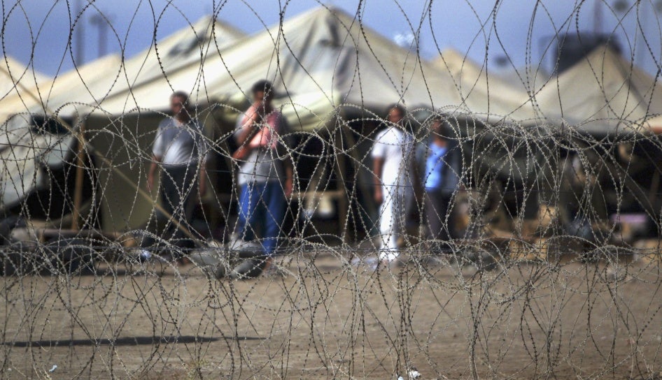 Prisoners stand next to the tents in which they are housed at the Abu Ghraib prison west of Baghdad, Iraq, July 15, 2004.