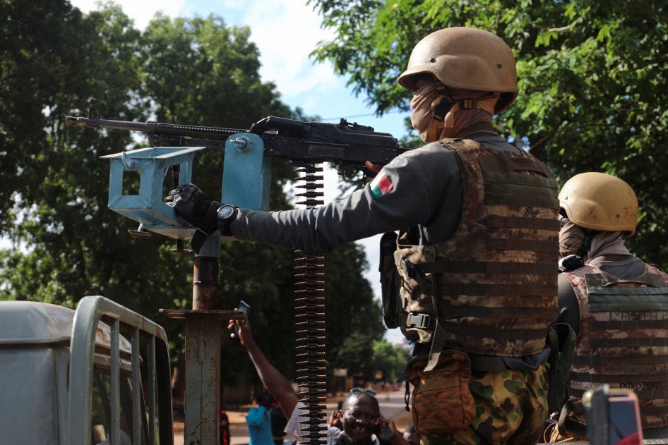 A Burkina Faso soldier stands guard in armored vehicle