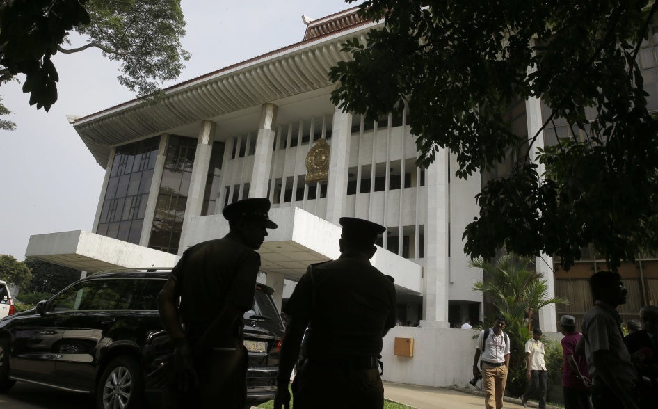 Police officers stand in front of a building.