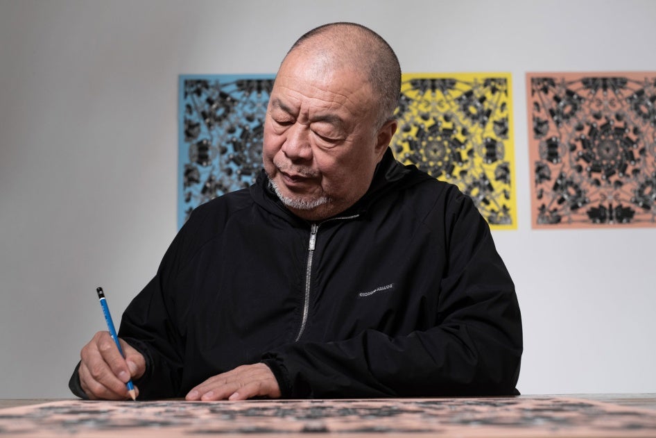 Artist Ai Wei Wei signs a lithograph print