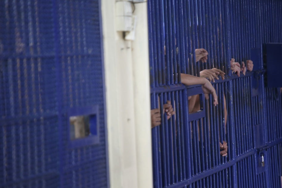 Detainees stand behind cell bars at the police immigration detention center in Bangkok, Thailand, January 21, 2019.