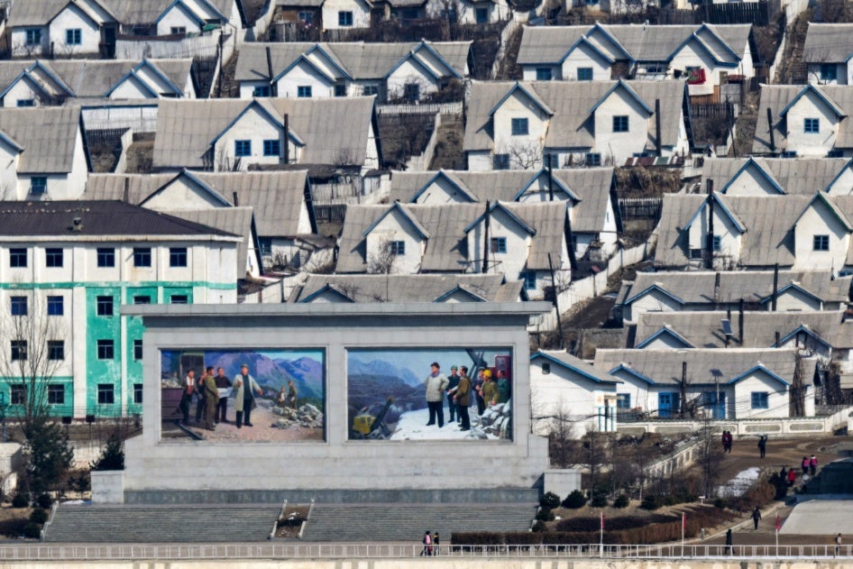 Rows of houses and a billboard in North Korea.