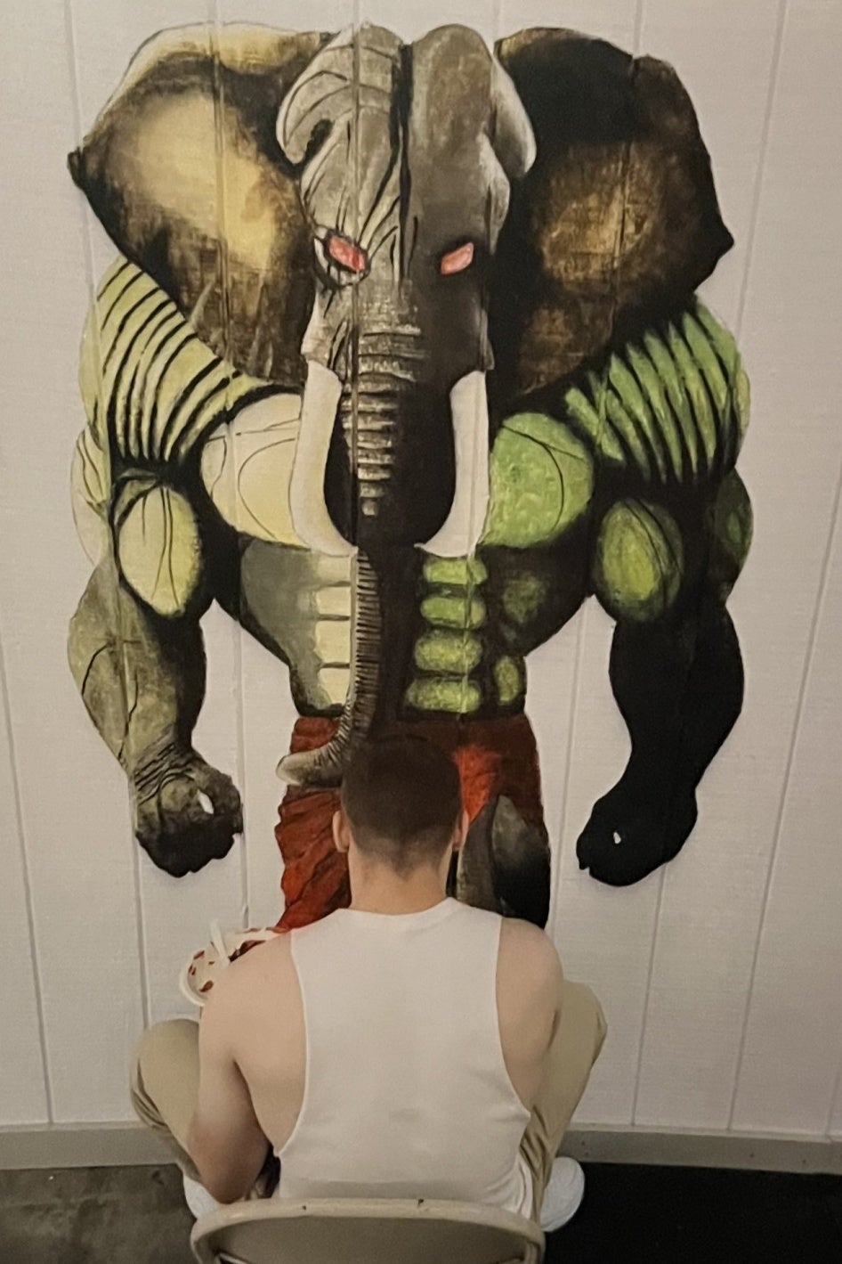 A youth paints a mural on a wall