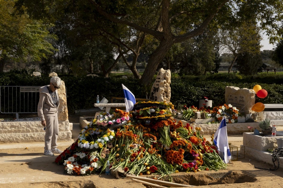 A mourner at the grave of hostages Shiri Bibas, Kfir Bibas and Ariel Bibas after their funeral on February 26, 2025, in Tzohar, Israel.