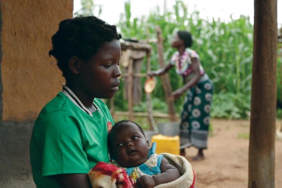A 14-year-old girl holds her baby at her sister’s home in a village in Kanduku, in Malawi’s Mwanza district. She married in September 2013, but her husband chased her away. Her 15-year-old sister, in the background, married when she was 12.