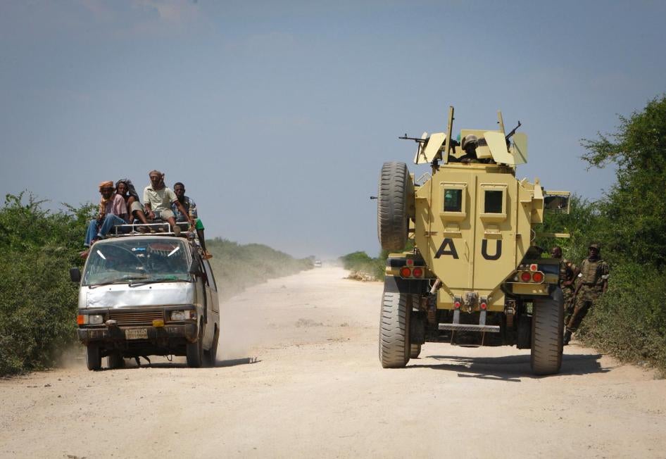 A commuter taxi drives past an African Union Mission in Somalia (AMISOM) armoured vehicle, December 2010 