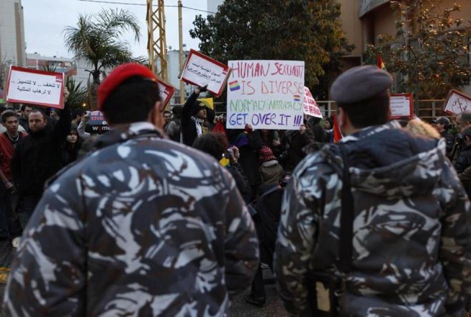 Lebanese police stand guard as protesters carry banners during a sit-in for LGBT rights in Beirut. 