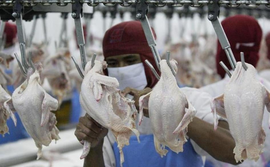 A worker cuts poultry at a factory in Chonburi province. 