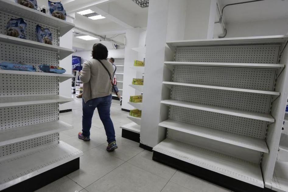 Una mujer camina al lado de estanterías vacías en una farmacia en Caracas, 23 de febrero de 2016.