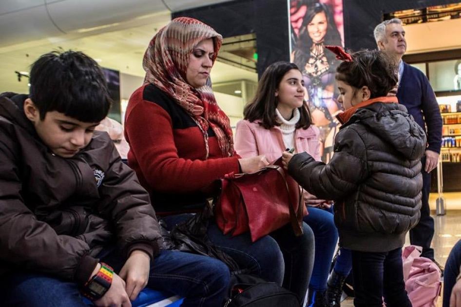 Dominique Osana waits in Athens airport with Falak and her children before the departure of Falak’s family to Dusseldorf, where they will be united with Falak’s husband and the children’s father through a family reunification programme.  © 2017 Anna Pante