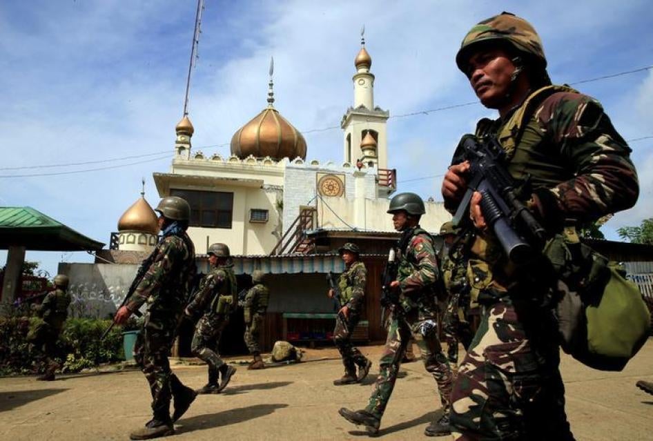 Government troops walk past a mosque before their assault with insurgents from the so-called Maute group, who have taken over large parts of Marawi City, southern Philippines on May 25, 2017