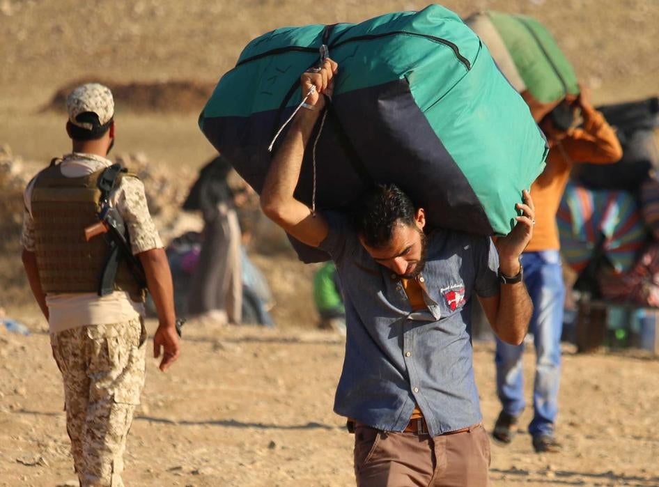 Syrian refugees carry belongings as they return to Syria after crossing the Jordanian border near the town of Nasib, in the southern province of Daraa, on August 29, 2017.  © 2017 Mohamad Abazeed, AFP, Getty Images