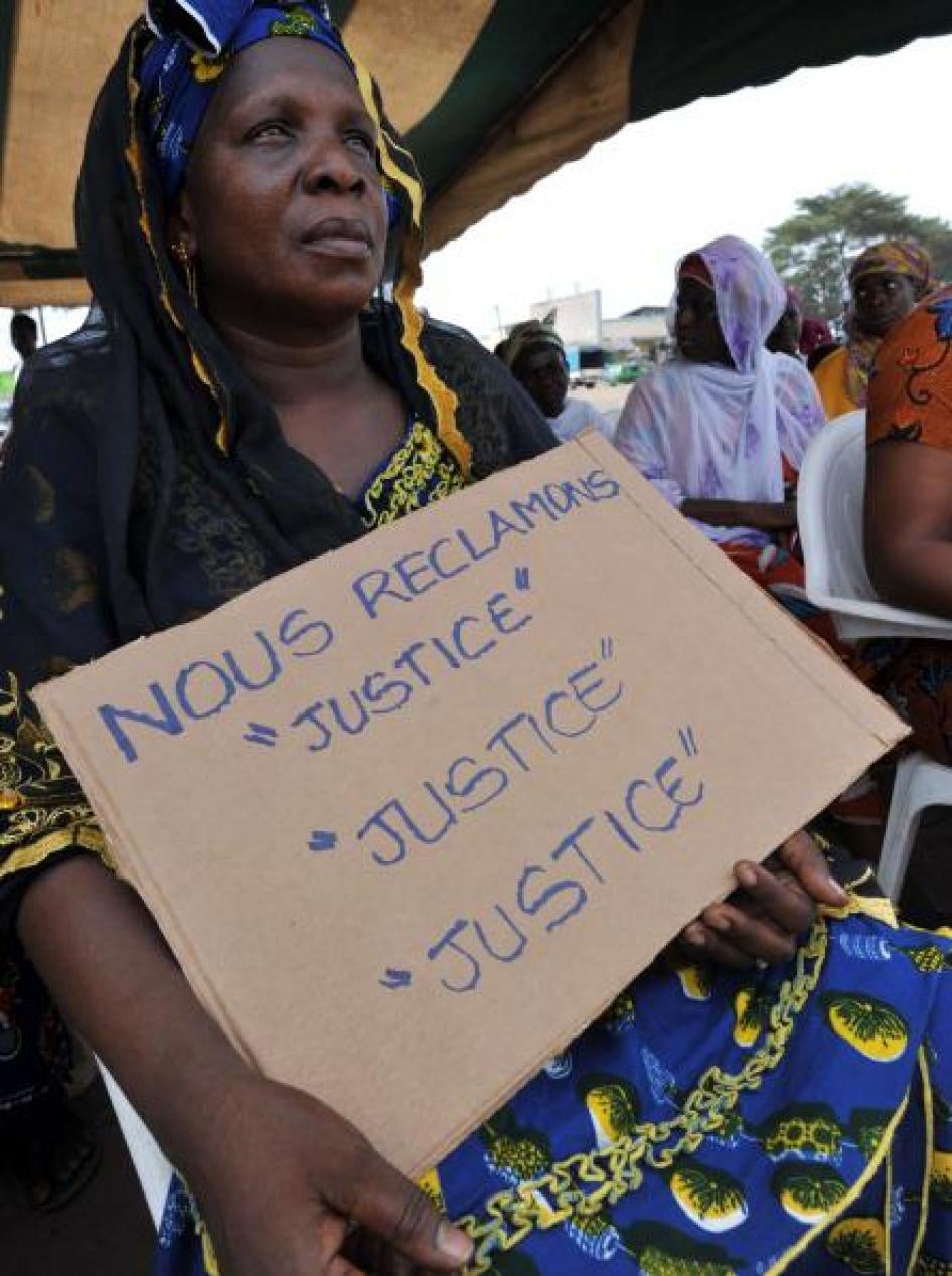 Victims of the 2010-11 post-election crisis hold placards reading 'We claim justice, justice justice' at a gathering in the Kouassai district of Abidjan on February 28, 2013, during the International Criminal Court’s confirmation of charges hearing agains