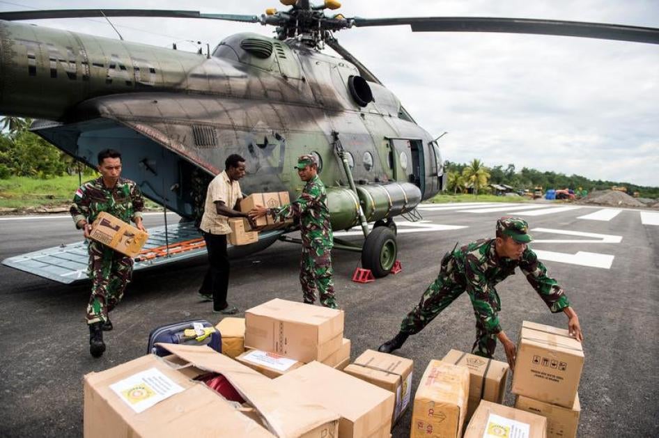 Indonesian soldiers along with a local resident unload food and medical aid in Ewer, Asmat District, in the remote region of Papua, Indonesia January 29, 2018 in this photo taken by Antara Foto.