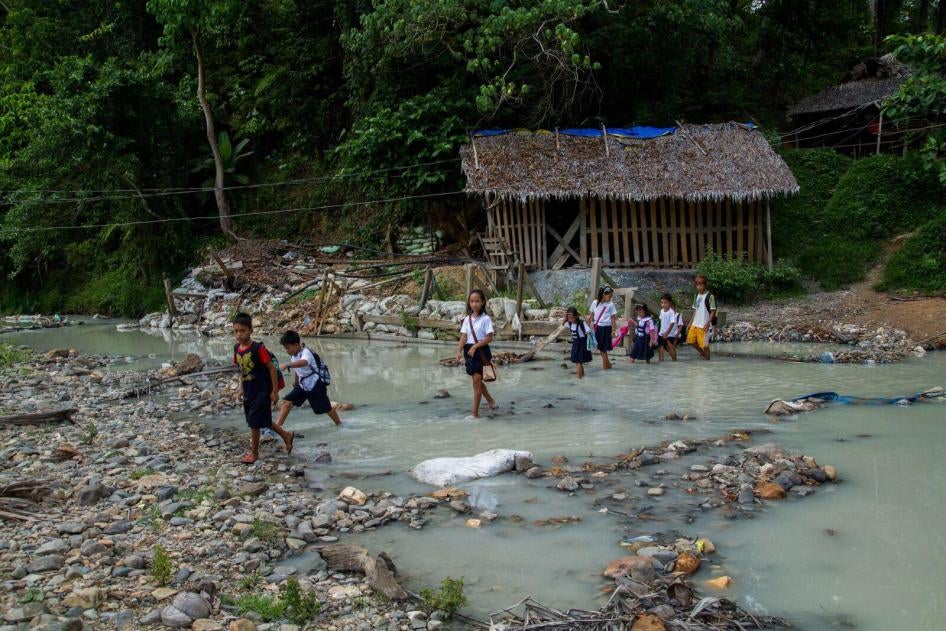 School children cross a mercury-polluted river in Malaya, Camarines Norte, Philippines.
