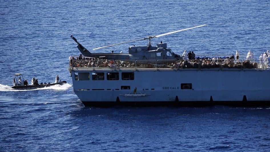 Migrants are transfered by Italian sailors from the German combat supply ship 'Frankfurt am Main' to the their ship 'Grecale' after being rescued during EUNAVFOR MED Operation Sophia in the Mediterranean Sea off the coast of Libya, March 29, 2016.