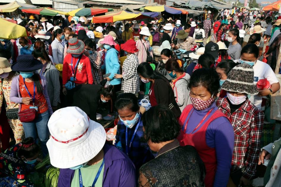 Garment factory workers wear face masks as they walk out at the end of their work shift March 20, 2020, near Phnom Penh, Cambodia.