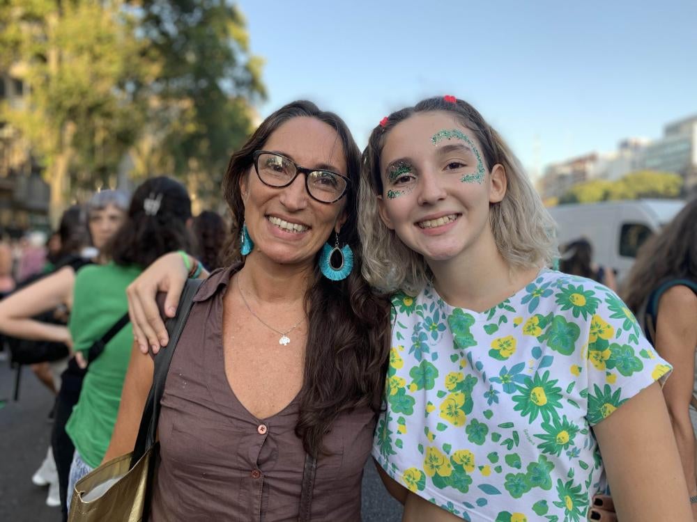 Two women smile and pose for a photo