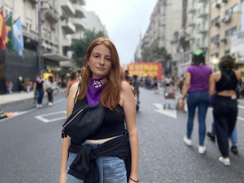 A woman poses in a city street 