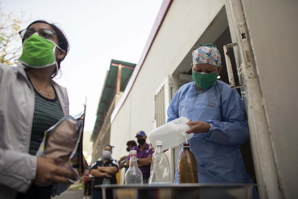 A nurse fills an empty plastic bottle with water